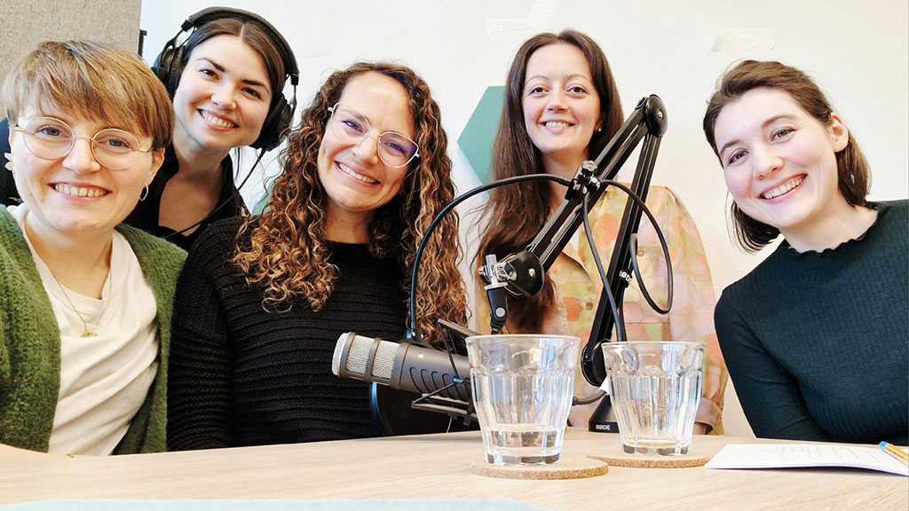 Foto von fünf Frauen vor einem Mikrofon